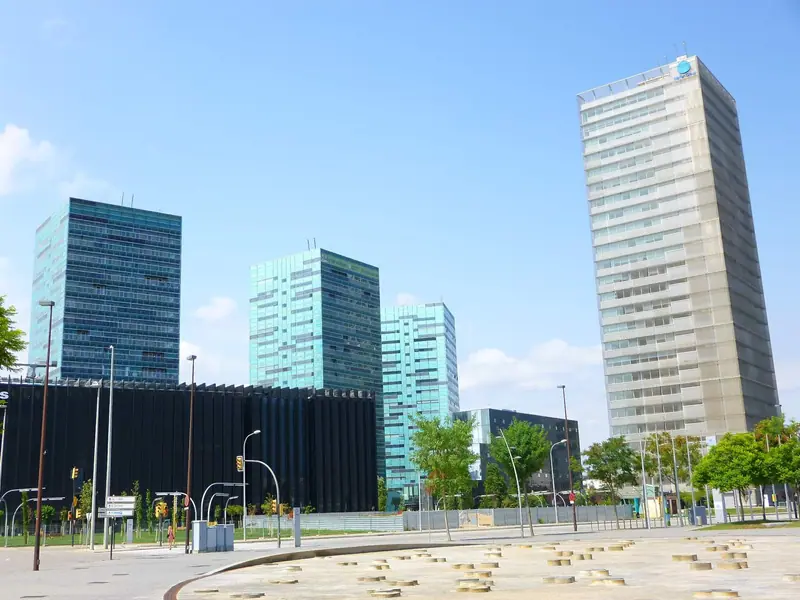 Torres de oficinas y viviendas de cristal azul y verde en la plaza de Europa, bajo un cielo despejado
