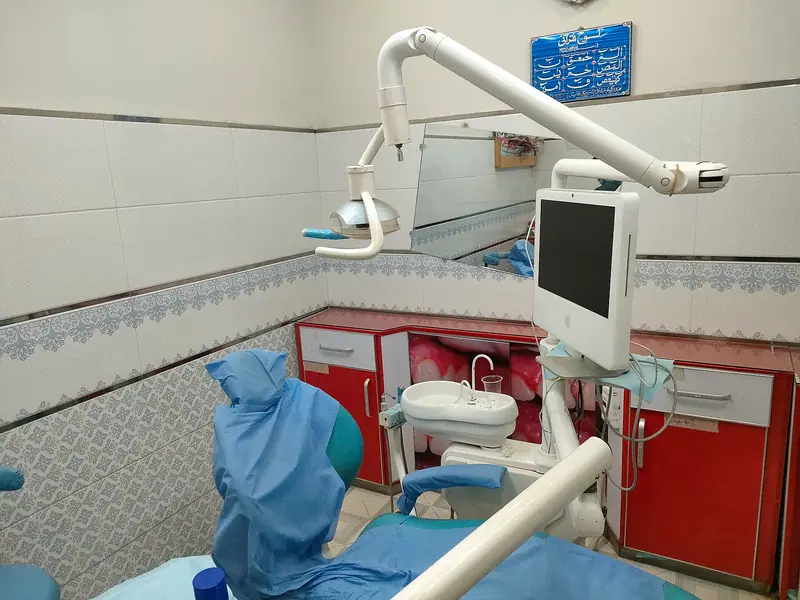 Sillón dental azul con su lámpara, el monitor y el instrumental en una consulta de dentista
